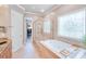 Bright bathroom with a glass-enclosed shower, soaking tub, and access to a walk-in closet at 4071 King Wilkinson Rd, Lincolnton, NC 28092