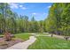 Scenic view of lush front yard with winding walkway and mature trees at 4071 King Wilkinson Rd, Lincolnton, NC 28092