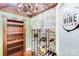 Charming wine cellar with custom racks, wood ceiling, chandelier, and concrete accent wall at 4071 King Wilkinson Rd, Lincolnton, NC 28092