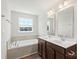 Bright bathroom featuring double sinks and a soaking tub under a large window at 408 Moondance Dr # C, Gastonia, NC 28054