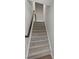 Carpeted staircase with wooden handrail provides a seamless transition between floors at 408 Moondance Dr # C, Gastonia, NC 28054
