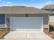 Two-car garage with a clean, modern door and exterior stone accents at 423 Wescott St # 73, Indian Trail, NC 28079
