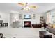 Comfortable living room featuring a cozy fireplace, soft lighting, and a ceiling fan at 4380 Timberwood Dr, Gastonia, NC 28052