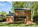 Brick home featuring a screened porch and mature landscaping at 4522 Woods End Ln, Charlotte, NC 28277