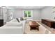 Bright living room with white couches, a coffee table, and a view of the backyard at 4522 Woods End Ln, Charlotte, NC 28277