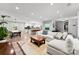 Open-concept living space with hardwood floors, white sofa, and access to the kitchen and dining areas at 4522 Woods End Ln, Charlotte, NC 28277