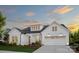 Beautiful, newly constructed white home with an attached garage, manicured lawn, and flower beds beneath a cloudy sky at 5205 Mint Harbor Way # 0353, Charlotte, NC 28269