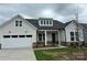 Charming home featuring a light gray exterior, a two-car garage and a welcoming front porch at 5205 Mint Harbor Way # 0353, Charlotte, NC 28269