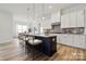 Modern kitchen boasts an island with barstool seating, sleek white cabinets, and pendant lighting above the island at 5205 Mint Harbor Way # 0353, Charlotte, NC 28269