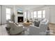 Bright living room with a fireplace, large windows dressed with curtains, and modern furniture arrangement over an area rug at 5205 Mint Harbor Way # 0353, Charlotte, NC 28269