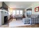 Cozy living room with a fireplace, hardwood floors, large windows, and comfortable plaid furnishings at 601 Meadowbrook Rd, Kings Mountain, NC 28086