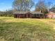 Charming brick home featuring a well-manicured lawn and quaint front porch at 614 Normandy Rd, Lancaster, SC 29720