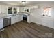 Modern kitchen boasts stainless steel appliances, white cabinets, a sink with window view, and wood-look flooring at 614 Normandy Rd, Lancaster, SC 29720