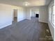 Open living room featuring neutral walls, gray carpet, a fireplace, and views to other rooms in the house at 614 Normandy Rd, Lancaster, SC 29720