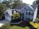 Overhead view of a gray two-story home with a manicured front lawn, colorful landscaping, and mature trees at 6325 Hawkwood Ln, Charlotte, NC 28277