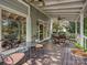 Outdoor back porch featuring a cozy seating area, ceiling fans, and view of the yard at 6325 Hawkwood Ln, Charlotte, NC 28277