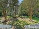 Manicured backyard featuring a lush lawn, mature trees, and a wooden fence for added privacy at 6325 Hawkwood Ln, Charlotte, NC 28277