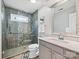 Bathroom featuring a stylish shower with glass doors, gray and white tile, and vanity with mirror at 6325 Hawkwood Ln, Charlotte, NC 28277