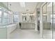 Bathroom featuring dual sinks, soaking tub, glass shower, and decorative chandelier at 6325 Hawkwood Ln, Charlotte, NC 28277