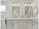 Bathroom featuring dual sinks, vanity with storage, and patterned tile backsplash at 6325 Hawkwood Ln, Charlotte, NC 28277