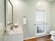 Bathroom featuring a white vanity, framed mirror, and a window with safety grab bar at 6325 Hawkwood Ln, Charlotte, NC 28277