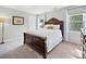 Bedroom featuring a large wooden bed with decorative pillows and natural light from nearby windows at 6325 Hawkwood Ln, Charlotte, NC 28277