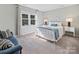 Bedroom featuring a white metal bed frame, side table, and striped accent pillows and couch at 6325 Hawkwood Ln, Charlotte, NC 28277