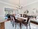 Elegant dining room with hardwood floors, a dark wood table, chandelier lighting, and easy access to the living area at 6325 Hawkwood Ln, Charlotte, NC 28277