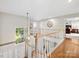 Upstairs hallway with hardwood floors, white railing, and decorative wall hangings at 6325 Hawkwood Ln, Charlotte, NC 28277