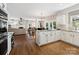 Bright kitchen with granite counters, white cabinets, and hardwood floors open to living room at 6325 Hawkwood Ln, Charlotte, NC 28277