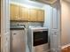 Laundry room featuring modern Maytag washer and dryer units, with ample cabinet space for storage at 6325 Hawkwood Ln, Charlotte, NC 28277