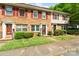 Traditional brick townhome with red shutters, green bushes, and a well-manicured front lawn at 6354 Old Pineville Rd # F, Charlotte, NC 28217