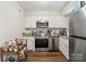 Functional kitchen featuring stainless steel appliances, white cabinets, and granite countertops at 6354 Old Pineville Rd # F, Charlotte, NC 28217