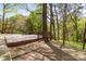 View of a backyard with a large deck surrounded by mature trees and a wooded fence line at 6614 Old Providence Rd, Charlotte, NC 28226