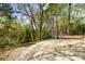 Large backyard with a deck and patio area surrounded by lush trees at 6614 Old Providence Rd, Charlotte, NC 28226