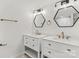 Elegant bathroom featuring dual sinks, white cabinets, and geometric mirrors at 6614 Old Providence Rd, Charlotte, NC 28226