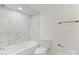 Bright bathroom with a tub, toilet, and luxurious marble-look tile at 6614 Old Providence Rd, Charlotte, NC 28226