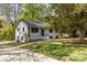 Side view of a renovated white painted brick home with mature landscaping and a charming front yard at 6614 Old Providence Rd, Charlotte, NC 28226