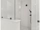 Sleek, all-white tiled shower with black hardware and pebble-style flooring at 6614 Old Providence Rd, Charlotte, NC 28226