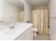 Bathroom featuring a white vanity, matching toilet, and a shower with yellow and gray patterned curtain at 7394 Echoing Hills Ln, Maiden, NC 28650