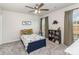 Bright, carpeted bedroom with a ceiling fan, dinosaur decor, and multiple windows at 7394 Echoing Hills Ln, Maiden, NC 28650