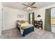 Bright, carpeted bedroom with a ceiling fan, dinosaur decor, and multiple windows at 7394 Echoing Hills Ln, Maiden, NC 28650