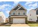 Charming two-story home featuring a brick-accented garage and light gray siding at 7394 Echoing Hills Ln, Maiden, NC 28650