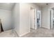 Upstairs hallway with neutral carpet and multiple doorways at 7394 Echoing Hills Ln, Maiden, NC 28650