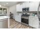 Modern kitchen with white cabinets, stainless steel appliances, and light countertops at 7394 Echoing Hills Ln, Maiden, NC 28650