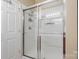 Shower with glass doors and tile, along with bright lights and a storage rack at 744 Ledgestone Ct, Tega Cay, SC 29708