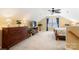 Comfortable carpeted bedroom with ceiling fan, window with curtains and plant decor at 744 Ledgestone Ct, Tega Cay, SC 29708