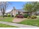 Charming stone home featuring a well-manicured lawn, mature landscaping, and inviting curb appeal at 744 Ledgestone Ct, Tega Cay, SC 29708