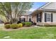 A stone home exterior with manicured lawn, shrubbery, and a cozy outdoor seating area at 744 Ledgestone Ct, Tega Cay, SC 29708