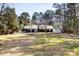 A backyard with a lush lawn, mature trees, and building at 7816 Wallace Ln, Charlotte, NC 28212